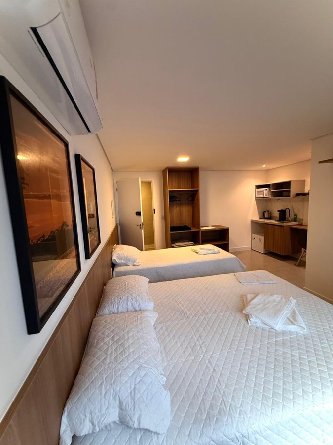 Quarto — Cama de casal, com quadro e iluminação de leitura.