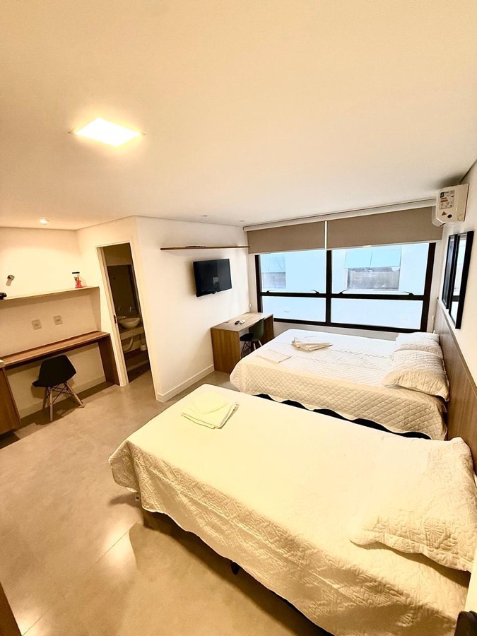 Quarto com vista — Cama de casal junto à janela.